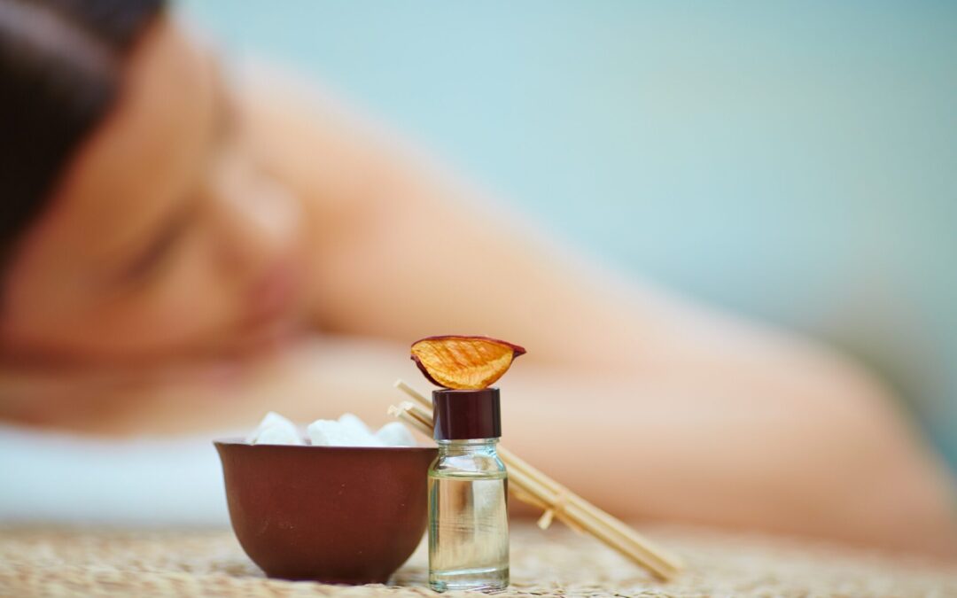 Woman relaxing during aromatherapy session with essential oil bottle, dried fruit slice, sugar cubes, and incense sticks for natural pain relief.