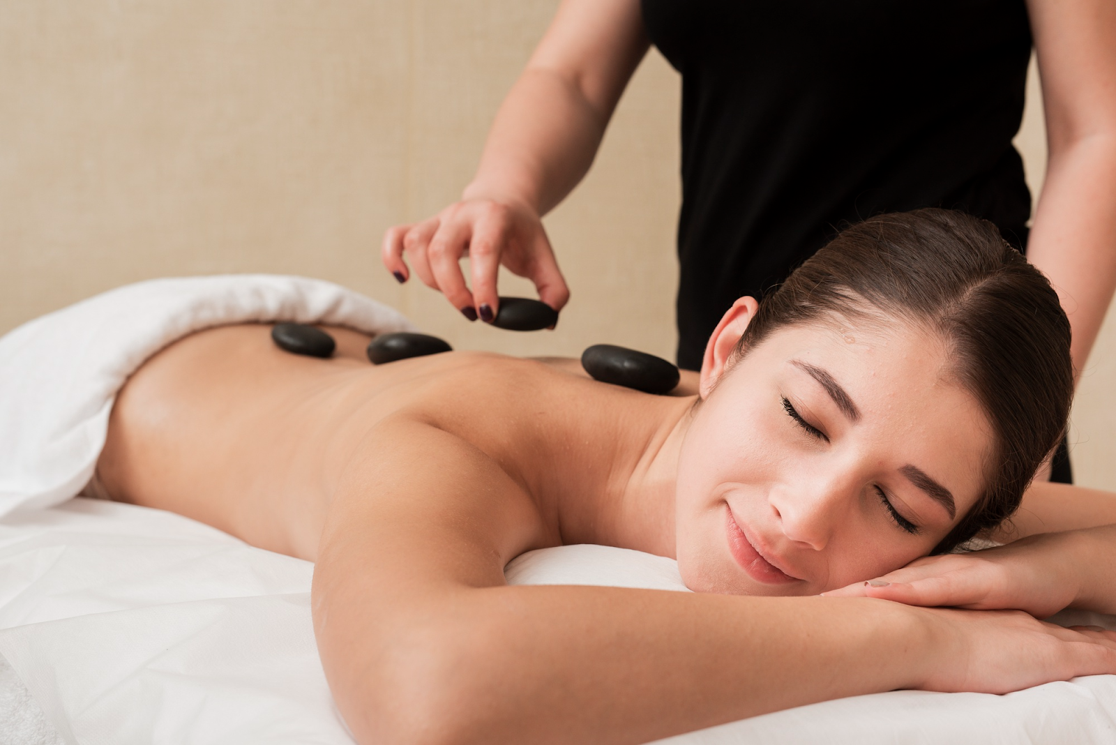 Relaxed woman experiencing the benefits of warm stone therapy.