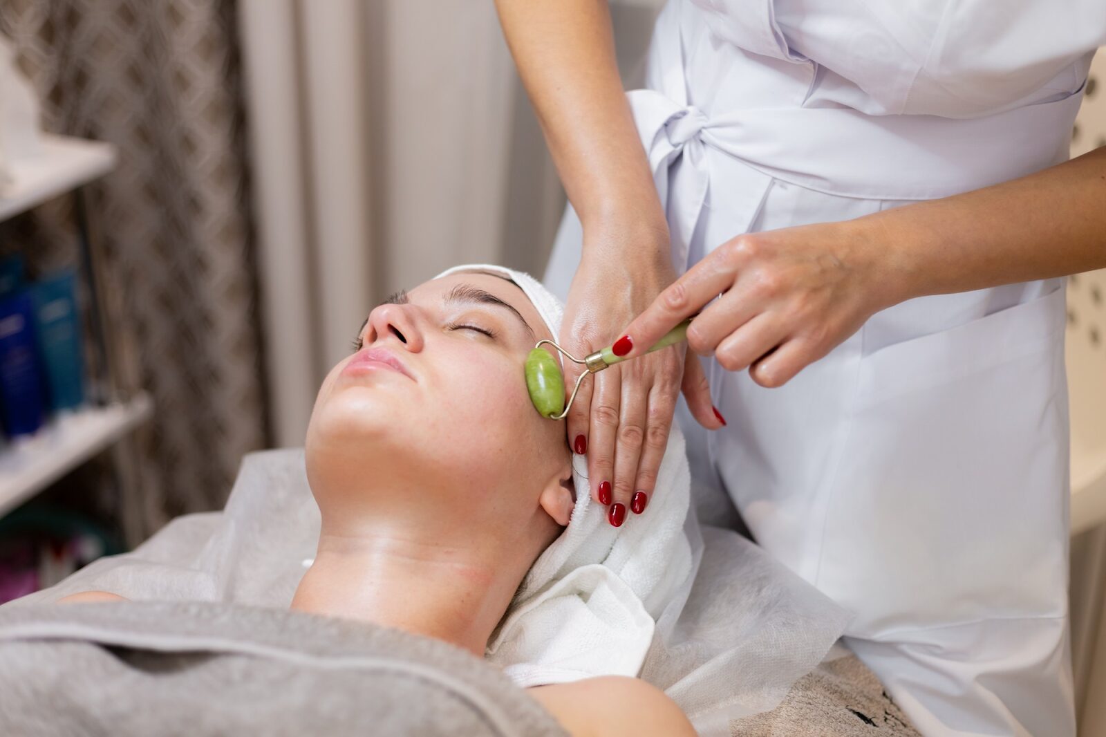 Therapist using a jade roller for a facial, a common treatment for skin detox and lymphatic drainage.